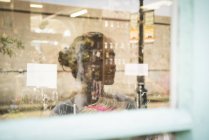 Reflection of woman in shop window — Stock Photo