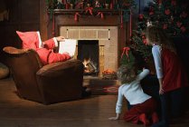 Children watching santa claus in living room — Stock Photo