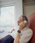 Пожилой человек с помощью мобильного телефона — стоковое фото