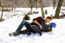 Romantisches junges Paar legt sich in den verschneiten Central Park, New York, USA — Stockfoto