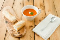 Close-up view of tomato soup and bread on wooden table — Stock Photo