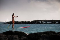 Surfer paddelt Surfbrett im Meer — Stockfoto