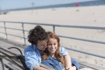 Coppia romantica sulla panchina del parco in spiaggia — Foto stock