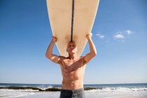 Surfeur portant une planche de surf sur la tête — Photo de stock