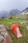 Tent pitched on rural hill witn mountain view — Stock Photo