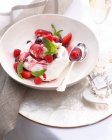 Bowl of pavlova with cranberries and raspberries — Stock Photo