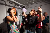 Pessoas usando máscaras de leão e tigre dançando na festa — Fotografia de Stock