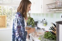 Frau in Küche bereitet Essen zu — Stockfoto