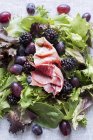 Зеленый салат с виноградом, ягодами и прошутто — стоковое фото
