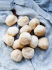 Pile of homemade bread rolls on tablecloth — Stock Photo