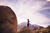 Mulher em pé no topo da rocha olhando para longe, Buttermilk Boulders, Bishop, Califórnia, EUA — Fotografia de Stock