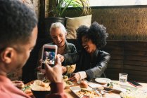 Uomo fotografare gli amici nel ristorante — Foto stock