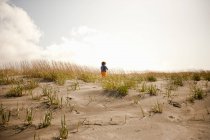 Boy running on sand dunes — Stock Photo