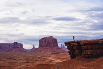 Silhouetted man on top of arenstone butte, Monument Valley, Arizona, USA — Foto stock