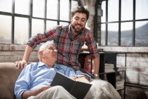 Father and son reading book at home — Stock Photo