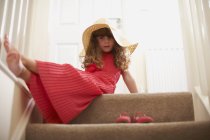 Retrato de menina na escada usando chapéu de palha — Fotografia de Stock