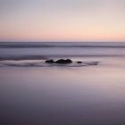 Вид на скелю в морі на заході сонця — стокове фото