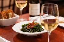 Накрытый стол с блюдами и белым вином в бокалах — стоковое фото