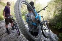 Coppia giovane con mountain bike su roccia — Foto stock