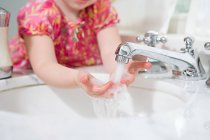 Девушка моет руки, обрезает изображение — стоковое фото