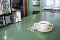 Kaffeetasse und Geld auf dem Tisch im Café — Stockfoto
