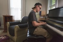 Портрет хлопчика підліткового віку, який грає на піаніно вдома — стокове фото