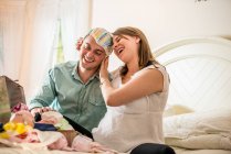Couple looking through case of baby clothes — Stock Photo