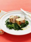 Plate of pork with mustard greens — Stock Photo