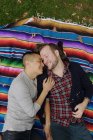 Gay couple on rainbow blanket — Stock Photo