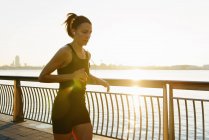 Jovem jogger feminino correndo ao nascer do sol — Fotografia de Stock