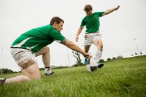 Rugby player kicking ball — Stock Photo