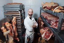 Butcher in meat storage area — Stock Photo
