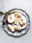 Нарезанное яблоко на тарелке — стоковое фото