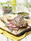 Roasted steak with herbs and knife on cutting board — Stock Photo