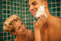 Mujer ayudando novio afeitarse - foto de stock