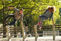 Пара прыгающих через скамейки в парке — стоковое фото