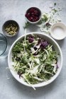 Top view of salad leaves in bowl with accompaniments — Stock Photo