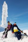 Snowboarder und Skifahrer am Gipfel des Berges mit Ausrüstung, vor Eisskulptur — Stockfoto