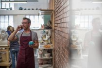 Кейптаун, Южная Африка, молодой мужчина по телефону в магазине керамики — стоковое фото