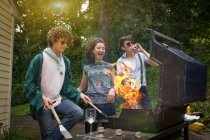Junge erwachsene Freunde genießen einen Grill im Hinterhof — Stockfoto