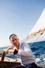 Mann steuert ein Segelboot — Stockfoto