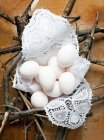 Still life with eggs on lace napkin with twigs — Stock Photo