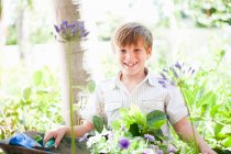 Boy potting plants outdoors — Stock Photo