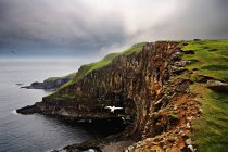 Sheer rock cliffs on coastline — Stock Photo