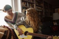 Teenagermädchen, eines spielt Gitarre — Stockfoto