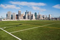 Soccer field and Lower Manhattan skyline in sunlight — Stock Photo