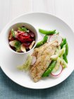 Teller mit gebackenem Fisch und Obstsalat — Stockfoto