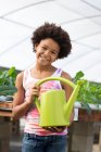 Girl holding green watering can — Stock Photo
