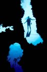 Silhouette plongeur à travers les coraux — Photo de stock
