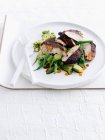Teller mit Cajun-Huhn und Salat serviert mit Besteck — Stockfoto